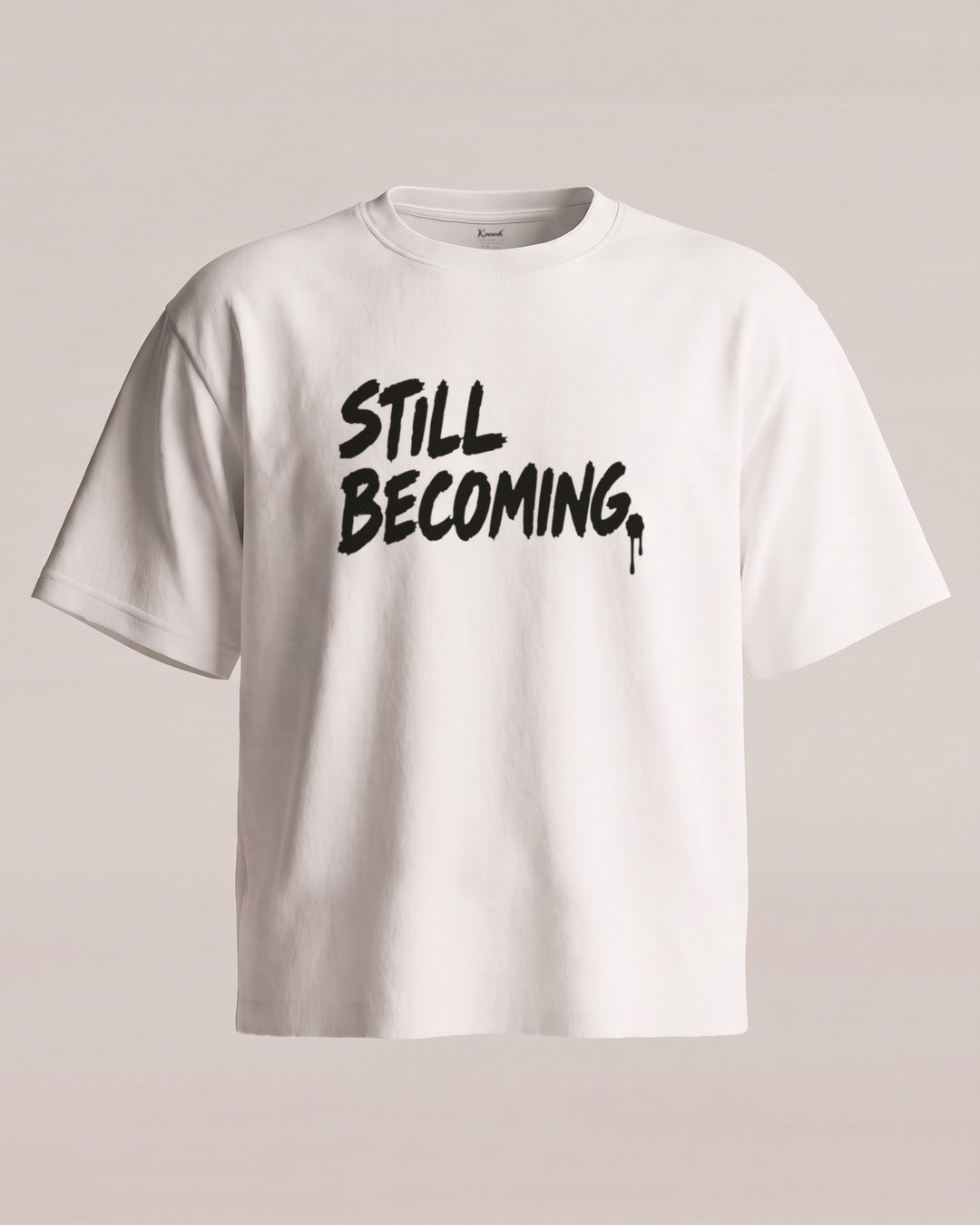 Tee 01, front: a white tee cut short with a raw hem, STILL BECOMING. in large black brush-style letters across the chest