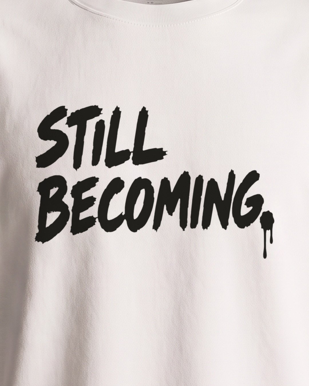 Close-up of the front print, STILL BECOMING. with a drip of paint running off the full stop